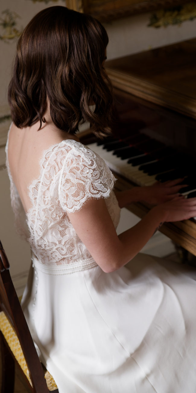 La robe de mariée Pénélope avec son dos nu bordé de dentelle est son décolleté cache coeur souligne la féminité de la future mariée avec élégance