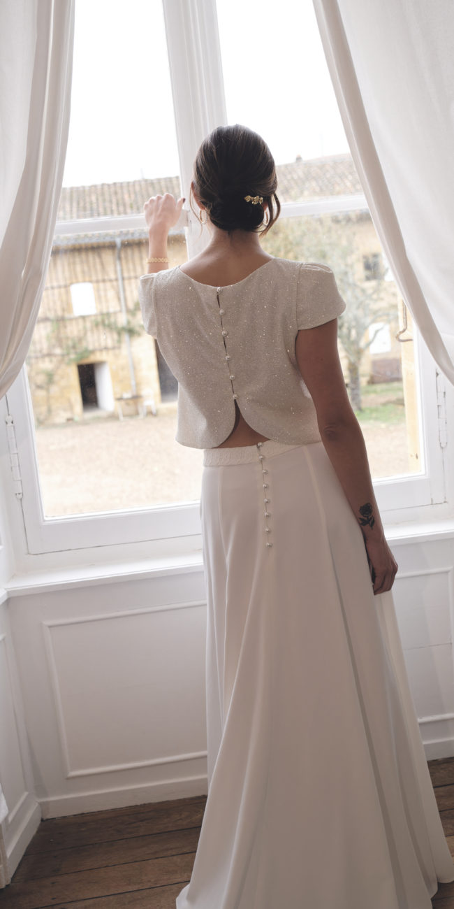 Une tenue de mariée minimaliste et raffinée avec ce top à paillettes et perles associé à une sculpturale jupe longue à traîne qui élance la silhouette